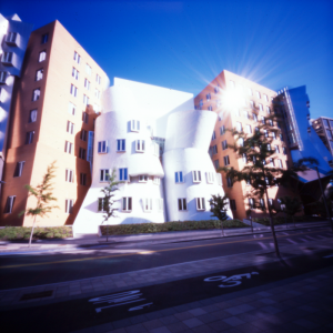 The vignetting effect of the pinhole creates a distinct bright spot in the center of the image. The pinhole also has a dramatic flare effect on the reflection of the sun on the windows which adds interest to the image .